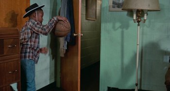 Movie still from “Cooley High” (1975), directed by Michael Schultz – A man holding a basketball in a room with green walls; Medium shot, High angle
