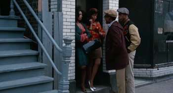 Movie still from “Cooley High” (1975), directed by Michael Schultz – A group of people standing on the steps of a building; Wide shot, Low angle