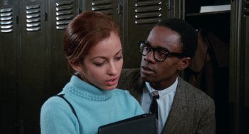 Movie still from “Cooley High” (1975), directed by Michael Schultz – A man and a woman are holding a tablet computer; Medium shot, Over the shoulder angle