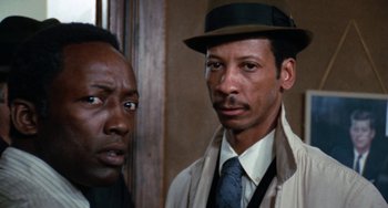 Movie still from “Cooley High” (1975), directed by Michael Schultz – A man in a hat and a man in a suit and tie; Close Up shot, Low angle