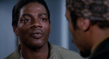 Movie still from “Cooley High” (1975), directed by Michael Schultz – A man in a military uniform looking at another man in a military fatigues; Close Up shot, Over the shoulder angle