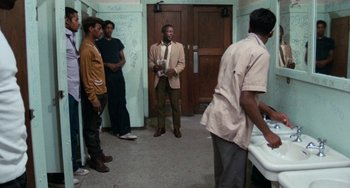 Movie still from “Cooley High” (1975), directed by Michael Schultz – A group of men standing around in a room; Wide shot, Low angle