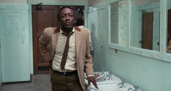 Movie still from “Cooley High” (1975), directed by Michael Schultz – A man standing in front of a bathroom sink; Medium shot, Low angle