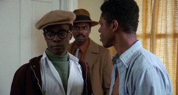 Movie still from “Cooley High” (1975), directed by Michael Schultz – A group of men standing next to each other in a room; Medium shot, Over the shoulder angle