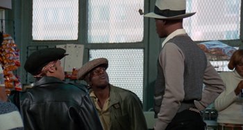 Movie still from “Cooley High” (1975), directed by Michael Schultz – A group of men standing next to each other in front of a window; Medium shot, Over the shoulder angle