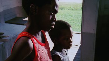 Movie still from “Coonskin” (1974), directed by Ralph Bakshi – Two young boys standing next to each other on a porch; Close Up shot, Low angle