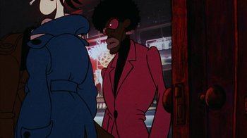 Movie still from “Coonskin” (1974), directed by Ralph Bakshi – A man in a red jacket is looking at another man in a blue jacket; Medium shot, Over the shoulder angle