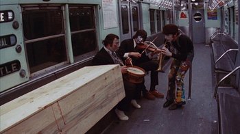 Movie still from “Coonskin” (1974), directed by Ralph Bakshi – A group of people sitting on a train; Wide shot, High angle