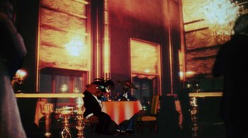 Movie still from “Coonskin” (1974), directed by Ralph Bakshi – Two people sitting at a table in front of a wine glass; Wide shot, Low angle