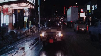 Movie still from “Coonskin” (1974), directed by Ralph Bakshi – Cars driving down a street at night in the rain; Extreme Wide shot, High angle