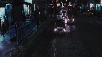 Movie still from “Coonskin” (1974), directed by Ralph Bakshi – Cars are driving down a street at night; Extreme Wide shot, High angle