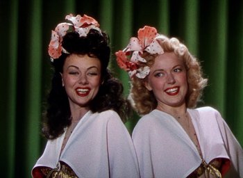 Movie still from “Cover Girl” (1944), directed by Charles Vidor – A couple of women standing next to each other on a stage; Close Up shot, Low angle