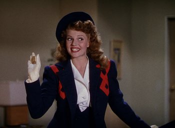 Movie still from “Cover Girl” (1944), directed by Charles Vidor – A woman wearing a hat and a jacket waving; Medium shot, Low angle