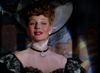 Movie still from “Cover Girl” (1944), directed by Charles Vidor – A person wearing a dress and a hat; Close Up shot, Low angle