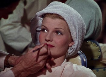 Movie still from “Cover Girl” (1944), directed by Charles Vidor – A woman is getting her makeup done by a man; Close Up shot, Over the shoulder angle