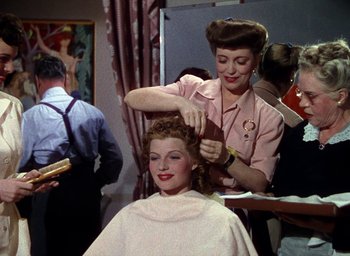 Movie still from “Cover Girl” (1944), directed by Charles Vidor – A woman getting her hair cut by a barber; Medium shot, Over the shoulder angle