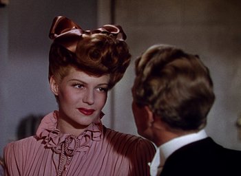 Movie still from “Cover Girl” (1944), directed by Charles Vidor – A woman in a pink dress and a man in a black suit; Close Up shot, Over the shoulder angle
