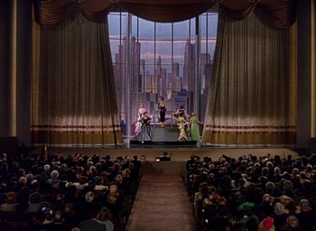 Movie still from “Cover Girl” (1944), directed by Charles Vidor – A large audience is sitting in front of a stage; Extreme Wide shot, Low angle