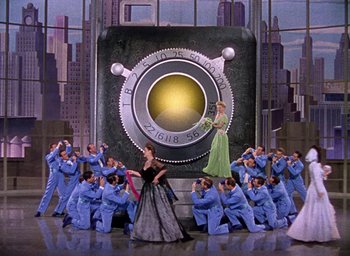 Movie still from “Cover Girl” (1944), directed by Charles Vidor – A group of people standing in front of a camera; Extreme Wide shot, Low angle