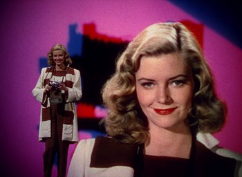 Movie still from “Cover Girl” (1944), directed by Charles Vidor – A woman is taking a picture in front of a painting; Medium shot, Low angle