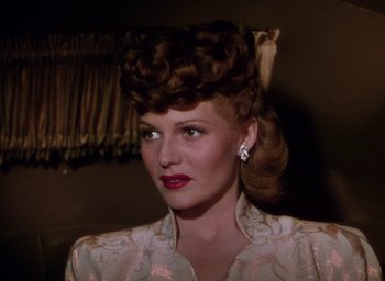 Movie still from “Cover Girl” (1944), directed by Charles Vidor – A woman in a white dress with a big hair style; Close Up shot, Low angle