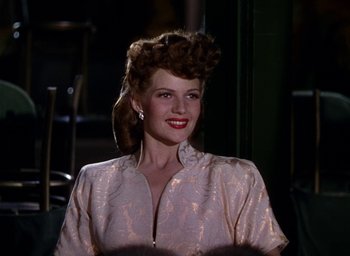 Movie still from “Cover Girl” (1944), directed by Charles Vidor – A woman in a white dress with a red lipstick; Close Up shot, Low angle