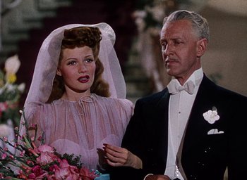 Movie still from “Cover Girl” (1944), directed by Charles Vidor – An older man and a young woman dressed in formal wear; Close Up shot, High angle