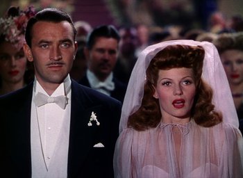 Movie still from “Cover Girl” (1944), directed by Charles Vidor – A man and a woman standing next to each other; Close Up shot, Low angle