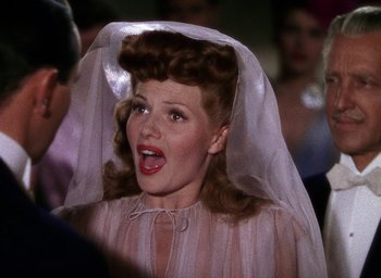 Movie still from “Cover Girl” (1944), directed by Charles Vidor – A woman in a wedding dress with a veil on her head; Close Up shot, Over the shoulder angle