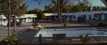 Movie still from “Crazy Heart” (2009), directed by Scott Cooper – An empty swimming pool sits in front of a motel; Extreme Wide shot, High angle