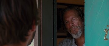 Movie still from “Crazy Heart” (2009), directed by Scott Cooper – A man with long hair and a goatee looking at himself in a mirror; Close Up shot, Over the shoulder angle