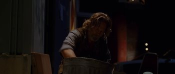 Movie still from “Crazy Heart” (2009), directed by Scott Cooper – A man with long hair and a goatee standing in front of a trash can; Medium shot, Low angle