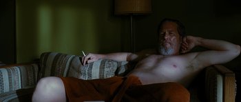 Movie still from “Crazy Heart” (2009), directed by Scott Cooper – A man laying in bed with a cigarette in his mouth; Medium shot, Low angle
