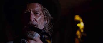 Movie still from “Crazy Heart” (2009), directed by Scott Cooper – A person wearing a hat and holding a microphone; Close Up shot, Low angle