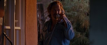 Movie still from “Crazy Heart” (2009), directed by Scott Cooper – A man talking on a phone while standing next to a tree; Medium shot, Low angle