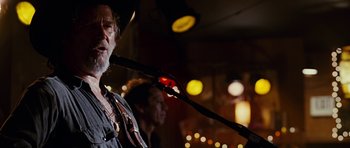Movie still from “Crazy Heart” (2009), directed by Scott Cooper – A man in a cowboy hat singing into a microphone; Close Up shot, Low angle