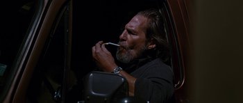 Movie still from “Crazy Heart” (2009), directed by Scott Cooper – A man smoking a cigarette while sitting in a car; Medium shot, Over the shoulder angle
