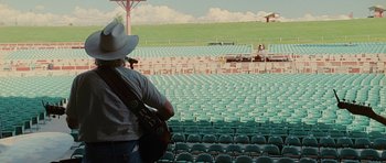 Movie still from “Crazy Heart” (2009), directed by Scott Cooper – A man with a guitar standing in a stadium; Extreme Wide shot, High angle