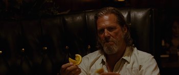 Movie still from “Crazy Heart” (2009), directed by Scott Cooper – A man sitting in a chair holding an orange slice; Close Up shot, Over the shoulder angle