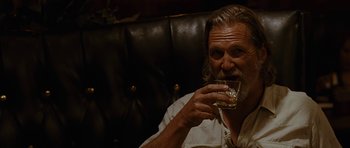 Movie still from “Crazy Heart” (2009), directed by Scott Cooper – An older man sitting in a chair drinking a glass of whiskey; Close Up shot, Over the shoulder angle