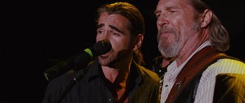 Movie still from “Crazy Heart” (2009), directed by Scott Cooper – A man singing into a microphone next to another man with a beard; Close Up shot, Low angle