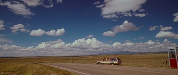 Movie still from “Crazy Heart” (2009), directed by Scott Cooper – A van driving down a road in the middle of a field; Extreme Wide shot, Low angle