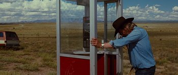 Movie still from “Crazy Heart” (2009), directed by Scott Cooper – A man in a cowboy hat leaning against a phone booth; Wide shot, Low angle