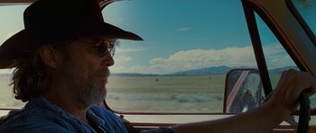 Movie still from “Crazy Heart” (2009), directed by Scott Cooper – A man with a hat and glasses sitting in a car; Close Up shot, Over the shoulder angle