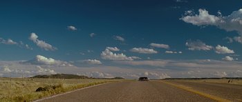 Movie still from “Crazy Heart” (2009), directed by Scott Cooper – A car driving down the middle of a road; Extreme Wide shot, Low angle