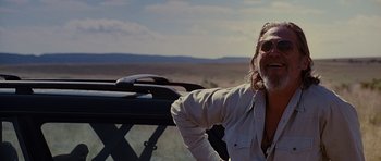 Movie still from “Crazy Heart” (2009), directed by Scott Cooper – A man in a white shirt and sunglasses is smiling; Medium shot, Low angle