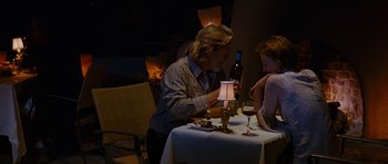 Movie still from “Crazy Heart” (2009), directed by Scott Cooper – A man and a woman sitting at a table with a bottle of wine; Medium shot, High angle
