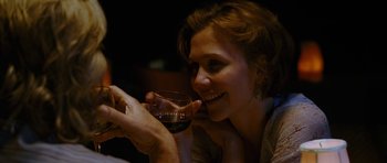 Movie still from “Crazy Heart” (2009), directed by Scott Cooper – A woman holding a glass of red wine in front of her face; Close Up shot, Over the shoulder angle