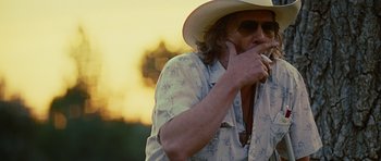 Movie still from “Crazy Heart” (2009), directed by Scott Cooper – A man in a cowboy hat is smoking a cigarette; Close Up shot, Over the shoulder angle