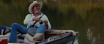 Movie still from “Crazy Heart” (2009), directed by Scott Cooper – A man sitting in a boat holding a fishing pole; Wide shot, Low angle